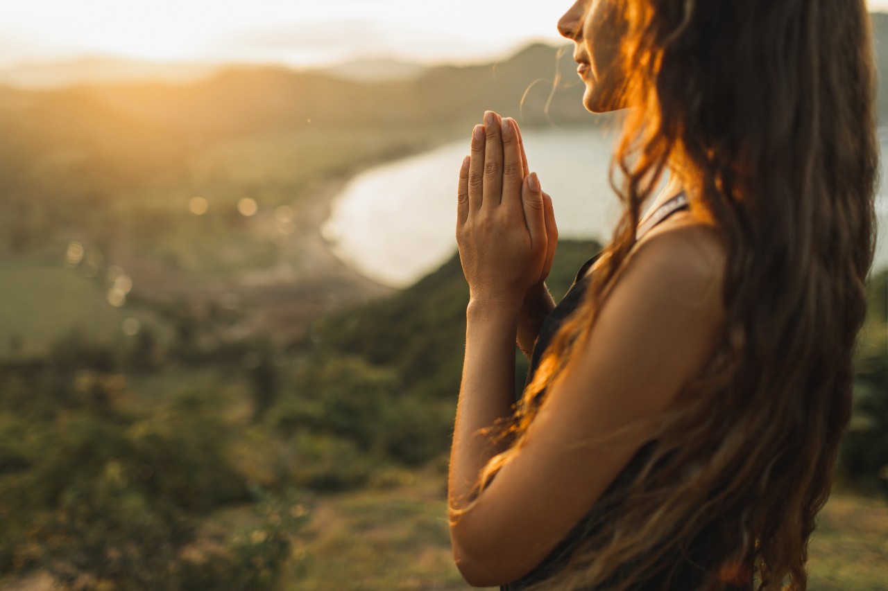woman-praying-alone-at-sunrise-nature-background